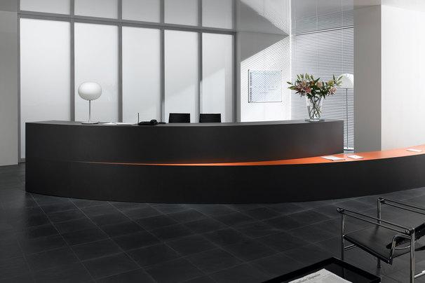Hotelrezeption mit schwarzem Einrichtungsstil Hotelrezeption mit schwarz lackierter Empfangstheke und orangenem Kontrast