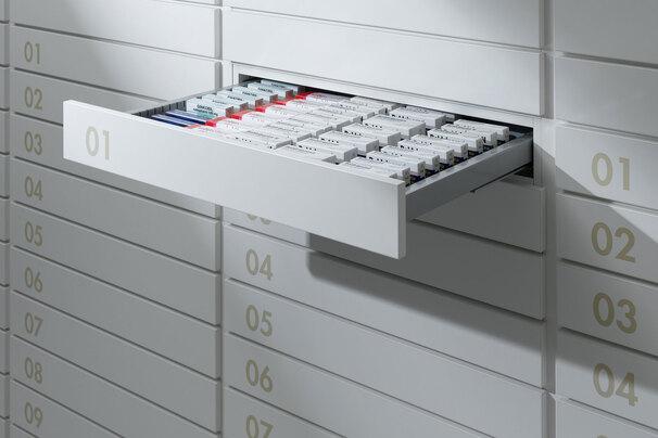 Detailaufnahme von Medikamentenschubläden Detailaufnahme von schmalen weißen Medikamentenschubläden mit dezenter Nummerierung und sichtbarer Medikamentenaufteilungen.
