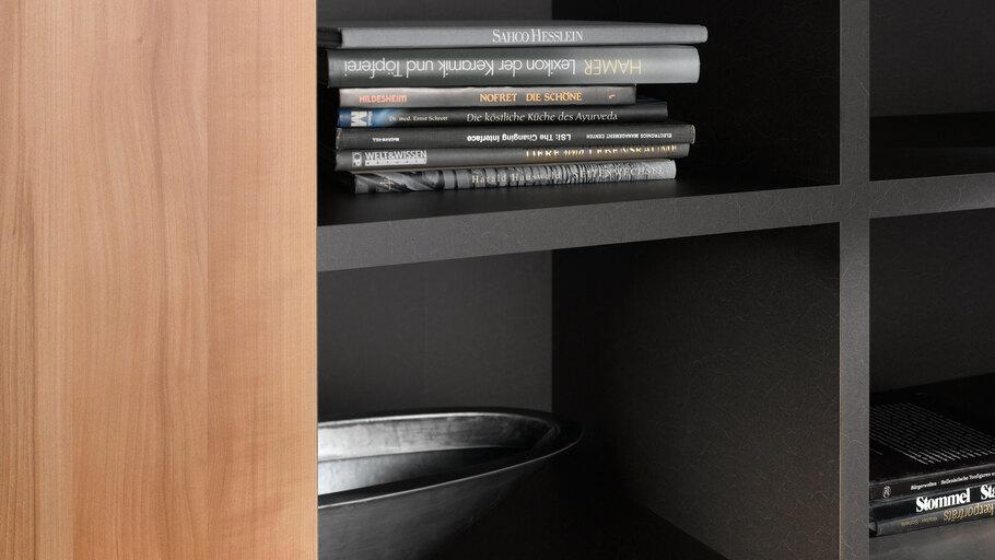 Detailaufnahme eines dunklen Regals Detailaufnahme eines schwarz lackierten Regals mit Büchern und Schale in Kombination mit naturbelassenem Holz.